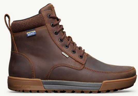 A brown leather high-top lace-up boot with a pull tab, black metal eyelets, and a brown and gray sole, shown from a side profile on a light off-white background. A small blue and white LEMS logo is visible on the ankle collar.