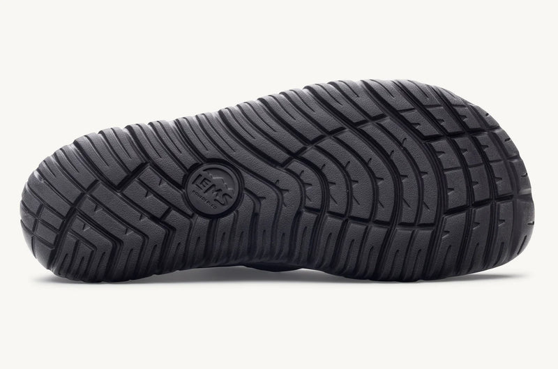 Load image into Gallery viewer, Close-up of a black shoe sole with tread pattern with a 'Lems' imprint
