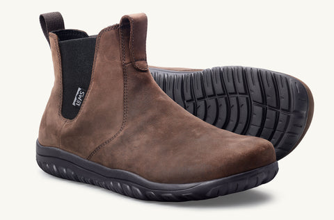 Load image into Gallery viewer, Brown Chelsea Boots that are waterproof and made of leather. Right foot is placed in normal position while other is on side to demonstrate the outsole.

