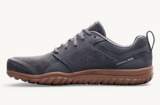 A Lems Primal Zen low-top shoe in dark gray suede and mesh with a brown gum sole, shown in a side profile on a light gray background.