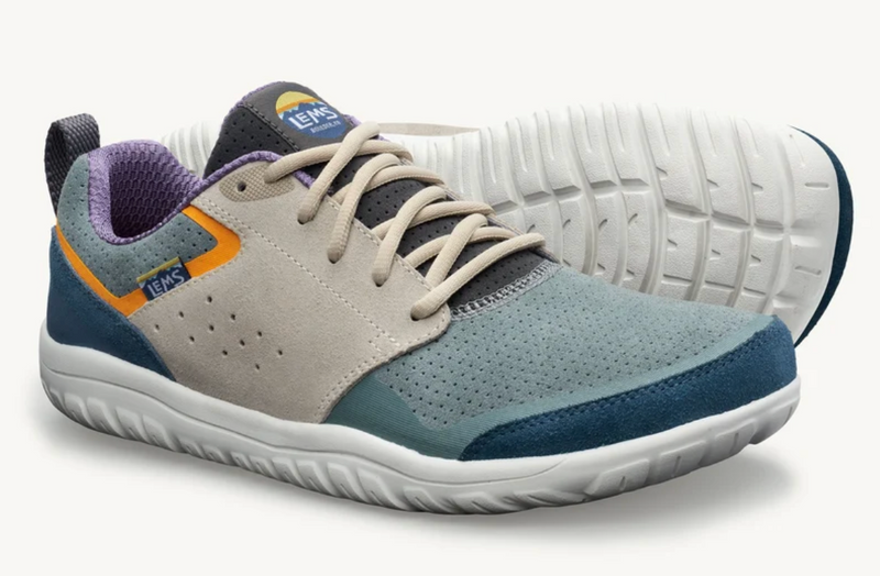 Load image into Gallery viewer, A pair of Lems barefoot-style athletic shoes in a muted colorway, featuring a light beige suede upper, teal mesh panels, dark blue toe and heel sections, a white sole, and purple lining accents.

